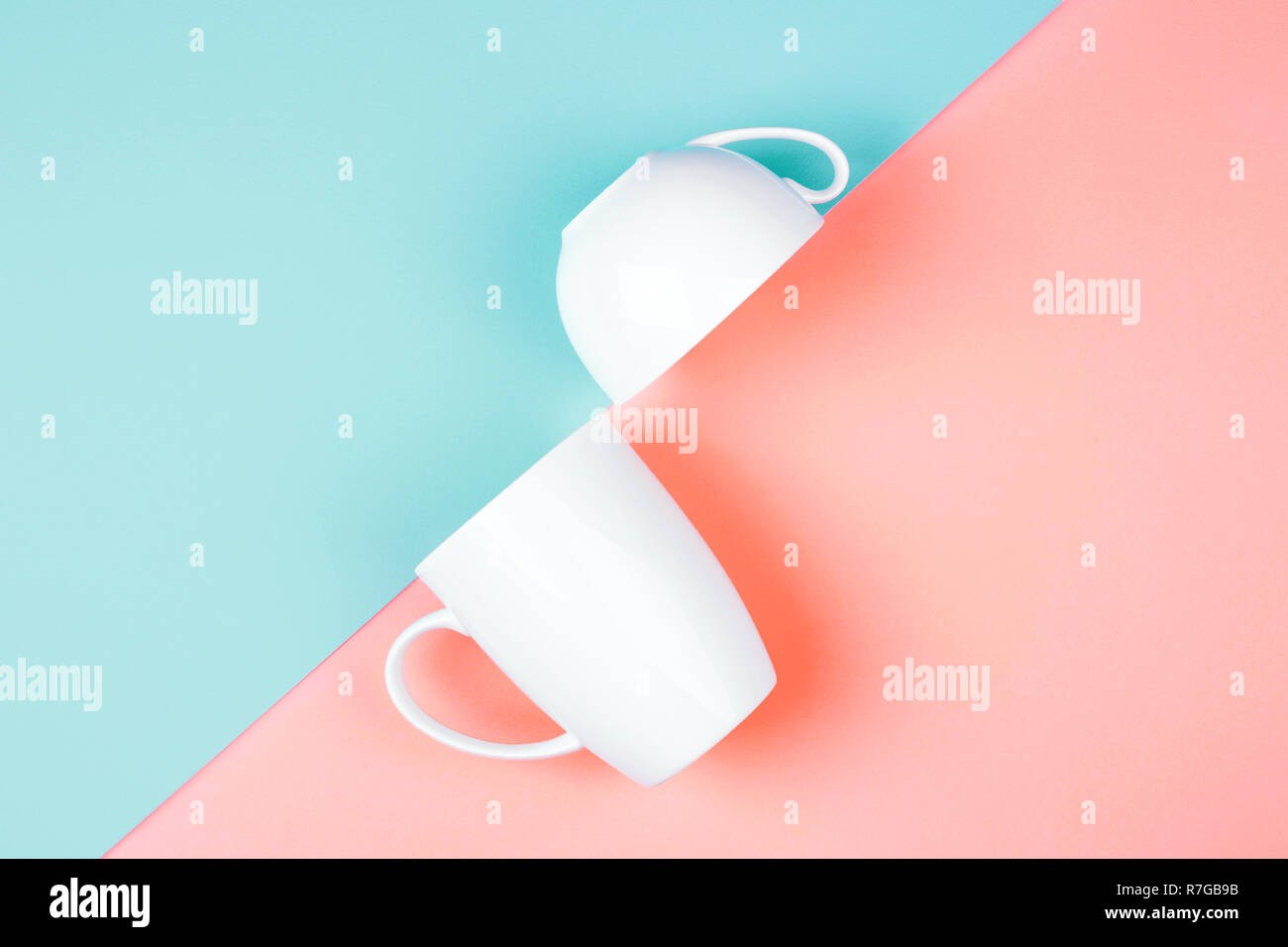 Zwei weiße Tassen auf farbigen Hintergrund. Abstrakt, Ansicht von oben. Lebende Korallen und Limpet Shell. Trendige Farben des 2019. Stockfoto