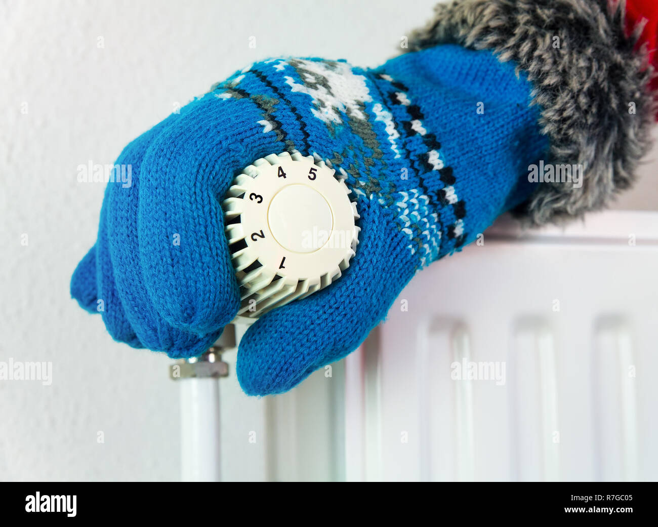 Hand mit Handschuh drehen Heizung Ventil öffnen im kalten Winter Stockfoto
