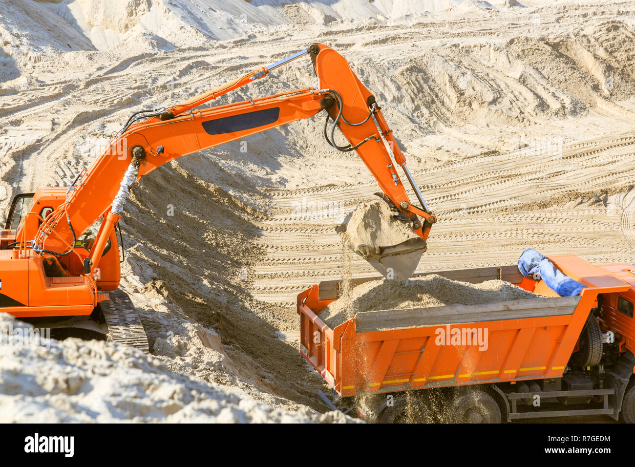 Arbeit der Bagger und Lkw an einer sand Steinbruch. Bagger laden Sand in einen Dump Truck. Stockfoto