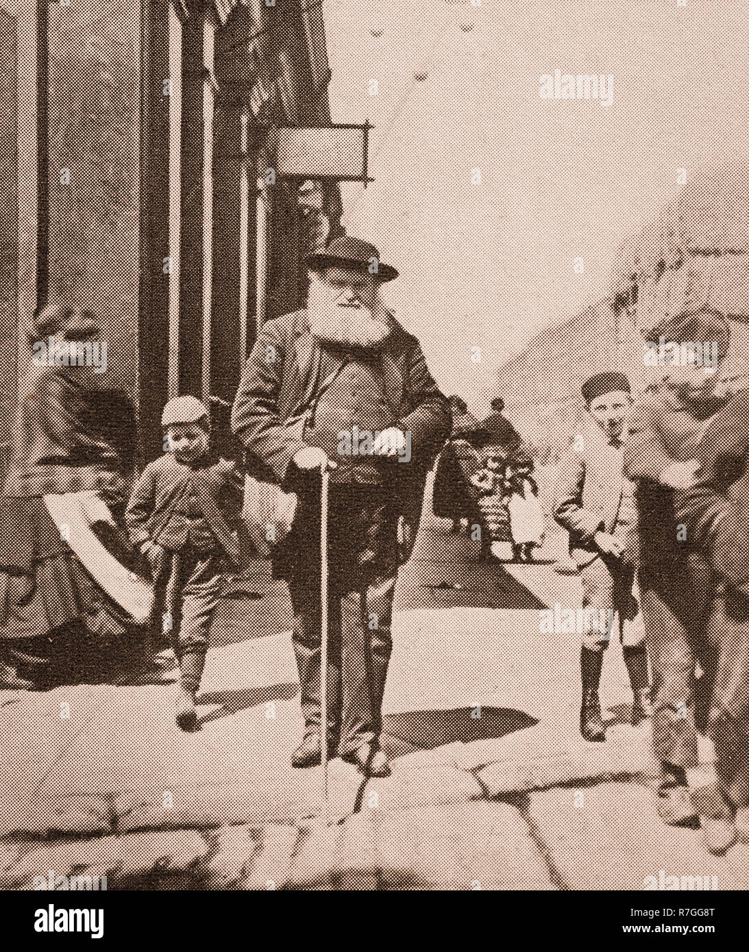 Leben für die Volksmusik im Viktorianischen Tage... Ein Blinder mit seinem weißen Stock und einem Gefolge von Kindern in großen Homer Street, Liverpool, Merseyside, England Stockfoto