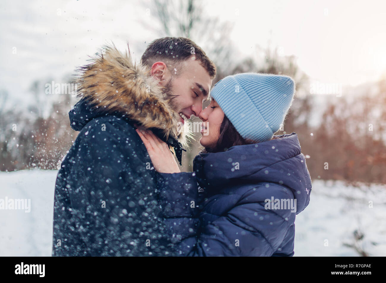Schöne liebevolle Paar und umarmen im Winter Wald. Menschen, die Spaß im Freien unter Schnee Stockfoto