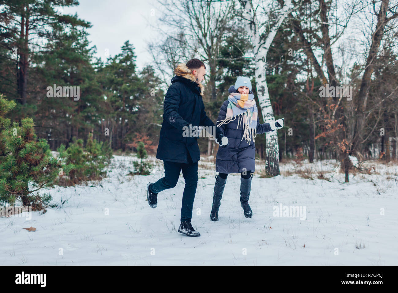 Schöne liebevolle Paar, dass Hände halten im Winter Wald zusammen. Menschen, die Spaß im Freien Stockfoto