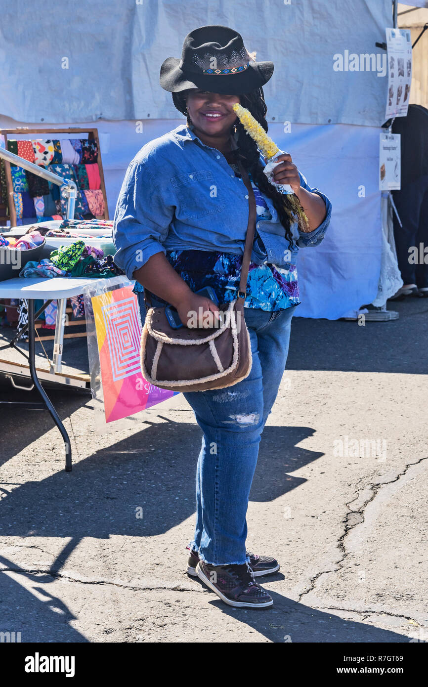 Lächelnd ziemlich Afrikanische amerikanische Frau Mais essen, Messe und Festival in Anchorage, Alaska, USA Stockfoto