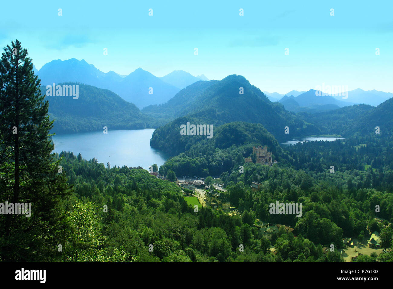 Alpine Landschaft mit Bergen in einem blauen Dunst, ruhigen Mirror Lake und alte Burg in einem Abstand Stockfoto