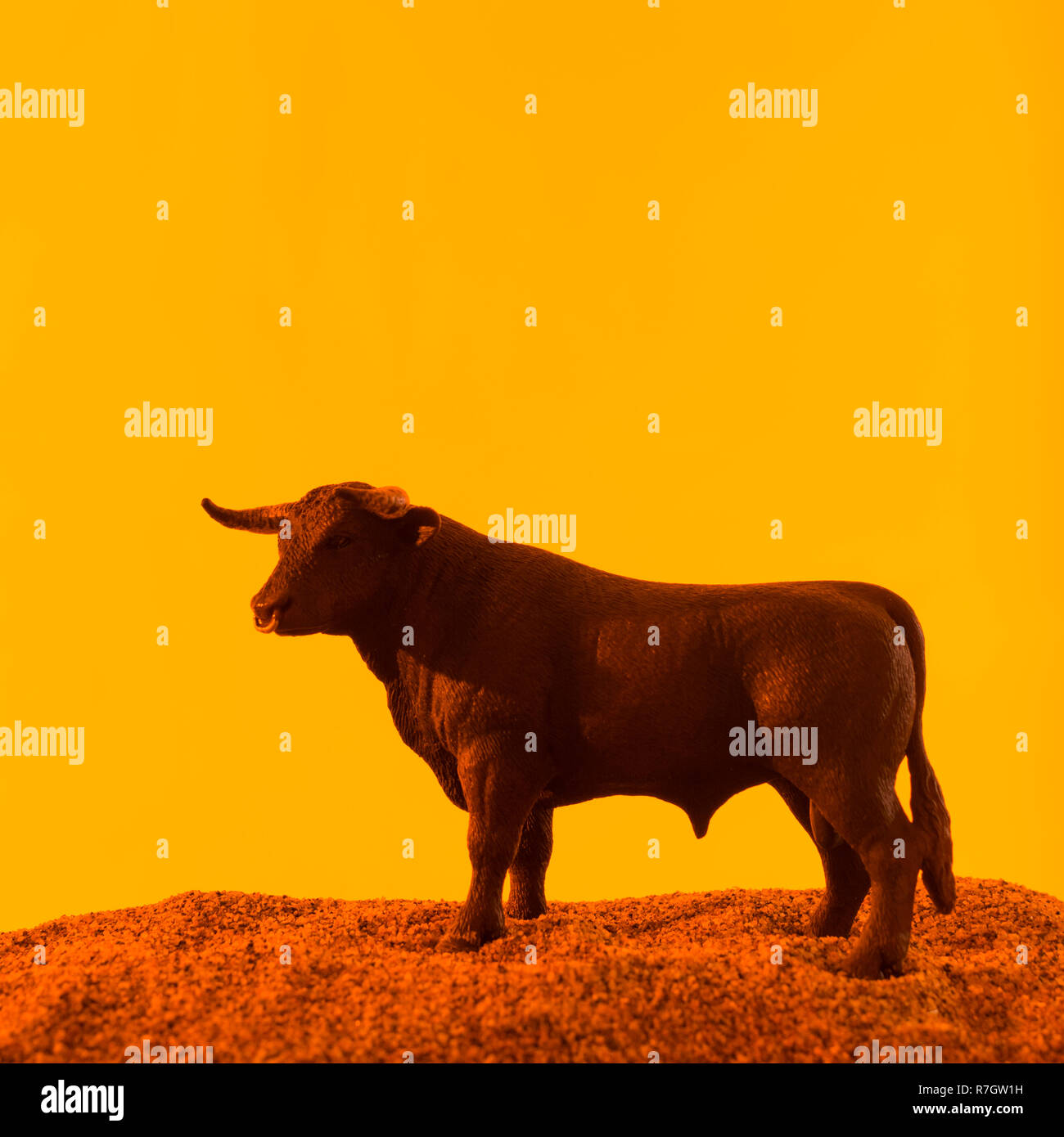 Spielzeug Stier gegen orange-gelb leuchtenden Sonnenuntergang Art Kulisse.  Metapher für 'Vertrauen' und Börse Stiere, Paarung. Siehe HINZUFÜGEN.  Informationen. HINWEIS Stockfotografie - Alamy