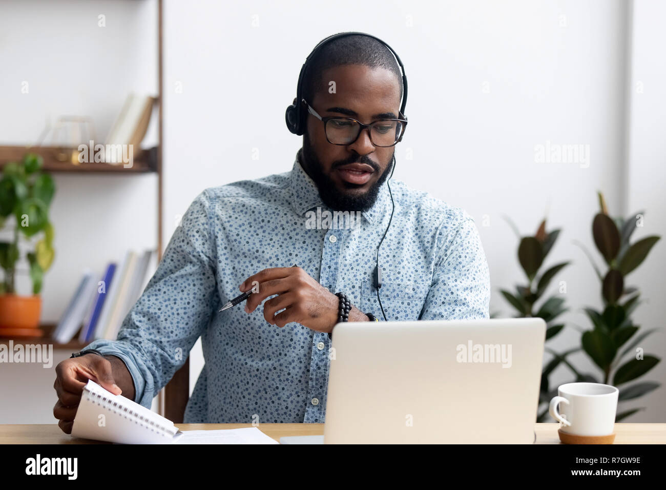 Mann mit Kopfhörern lernen Fremdsprache im Innenbereich Stockfoto