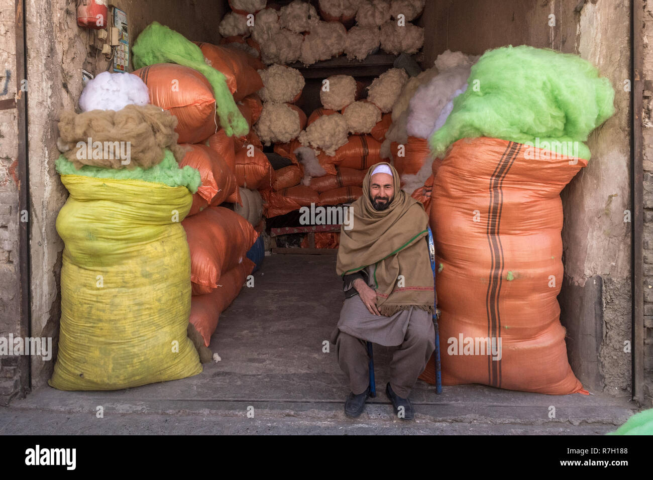 Ältere Basar Ladenbesitzer mit Baumwolle Taschen im Hintergrund, Herat, Provinz Herat, Afghanistan Stockfoto