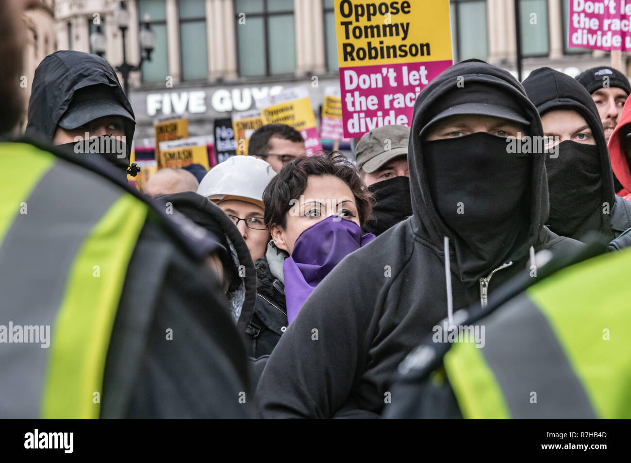 London, Großbritannien. 9 Dez, 2018. Eine Linie der Antifaschisten geht an der Vorderseite der Protest als Polizei im März zum Stillstand bringen, denn es gibt die Hooligans, die versucht, es zu stören. Die marchwas eine Gegendemonstration von antifaschisten Märsche im Gegensatz zu Tommy Robinson's faschistische pro-Brexit März. Die Polizei hatte die Bedingungen auf beiden Veranstaltungen konzipiert, die beiden Gruppen gut auseinander zu halten. Credit: Peter Marschall/Alamy leben Nachrichten Stockfoto