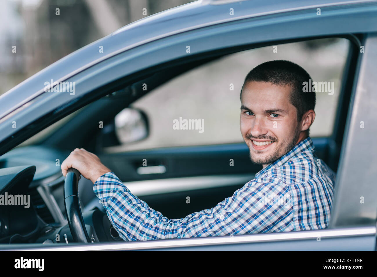 Seitenansicht. Ein junger Mann hinter dem Lenkrad sitzen Stockfoto