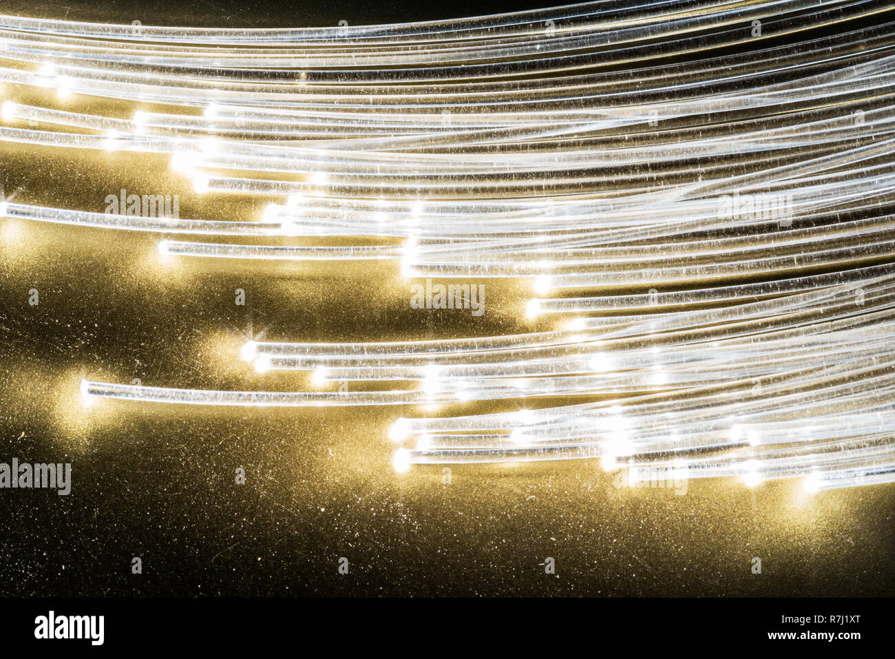 Bündel aus optischen Fasern mit Lichtern in den Enden. Gelber Hintergrund. Stockfoto