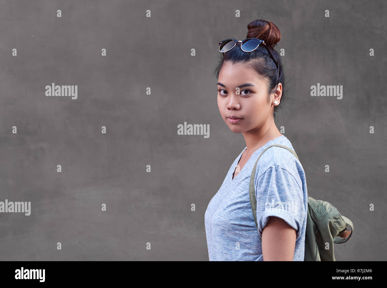 Zuversichtlich asiatische Frau stand vor einer Wand außerhalb Stockfoto