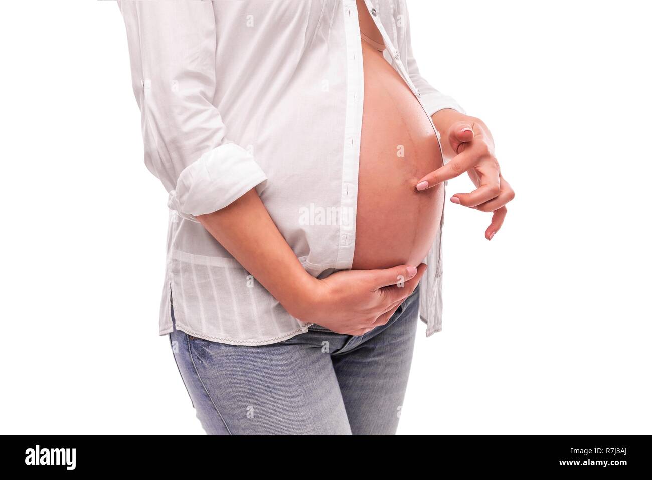 Schwangere Frau ihrem Bauchnabel Berühren mit dem Finger. Stockfoto