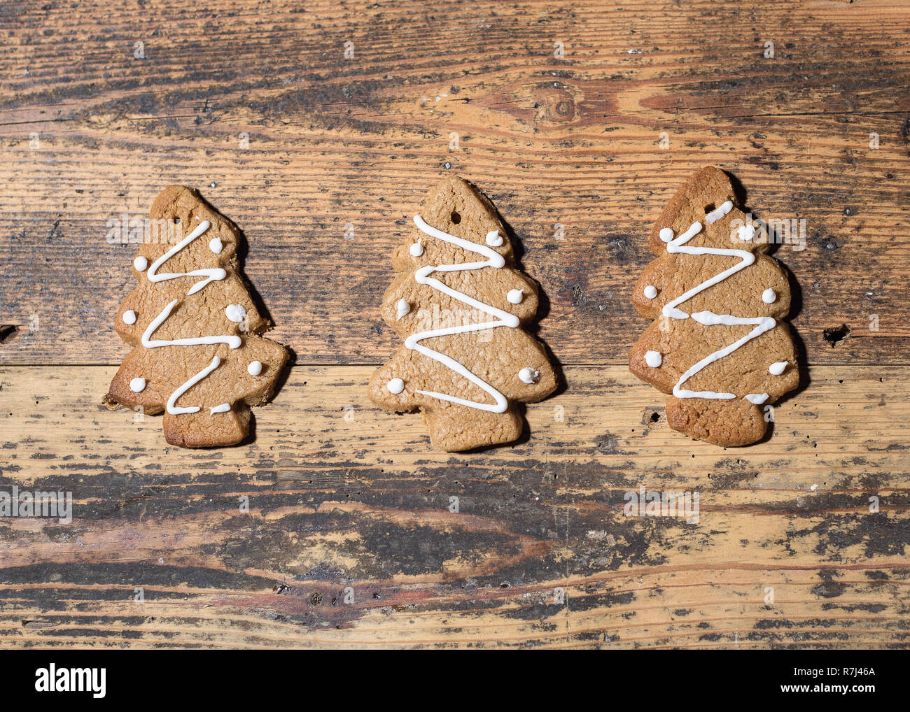 Drei Lebkuchen Weihnachten Kekse in einer Reihe, auf einer hölzernen Hintergrund, Landschaft Zusammensetzung Stockfoto