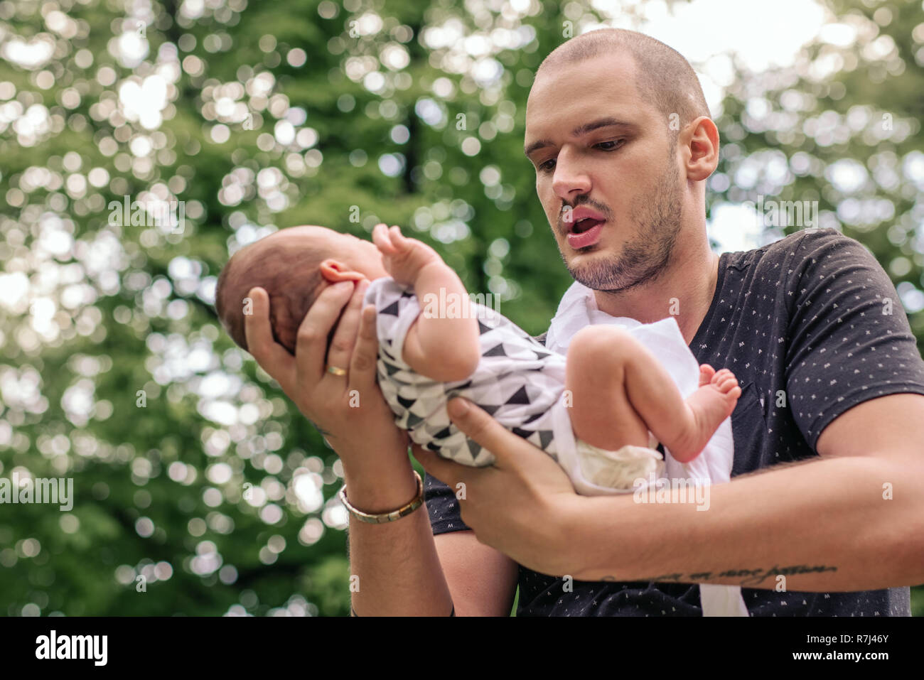 Junger Vater mit seinem Baby boy in seinen Händen außerhalb Stockfoto