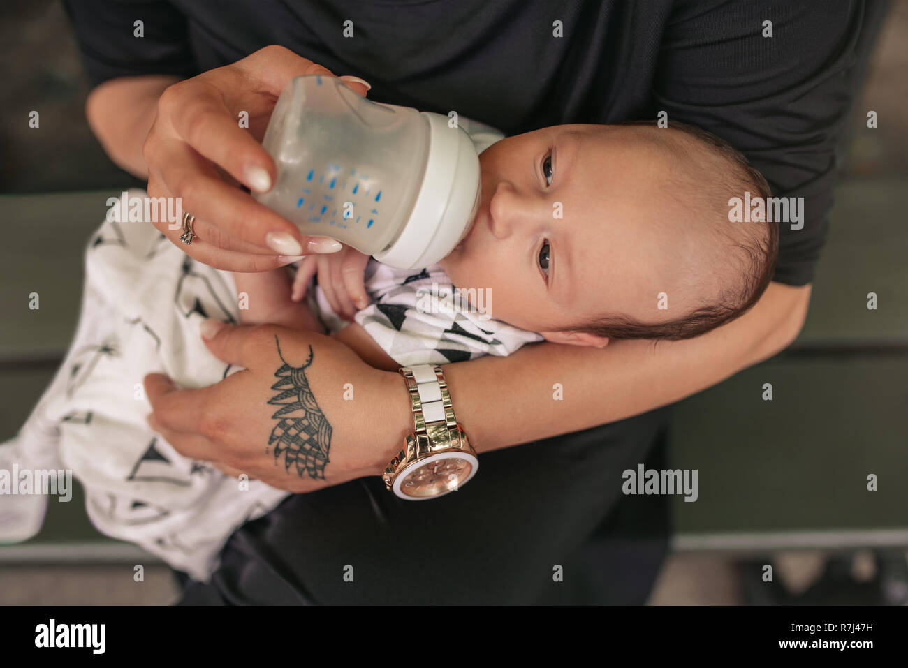 Mutter, der seine adorable Baby Junge mit einer Flasche Stockfoto