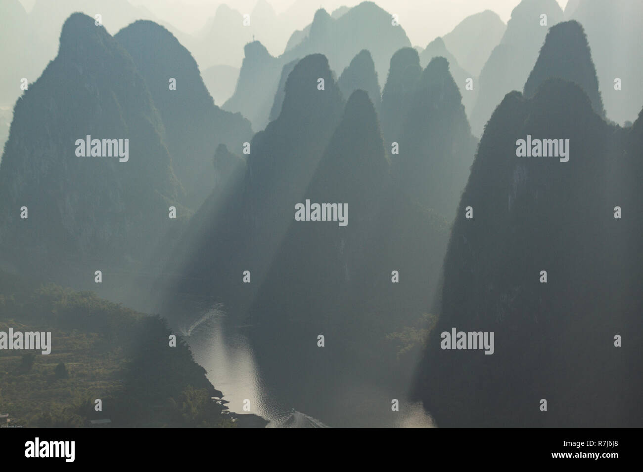 Karst Kalkstein Hügel in Silhouette bei Sonnenaufgang über den Li Fluss von Xianggong Mountain in der Nähe von Guilin, China gesehen. Sonnenstrahlen zwischen Hügeln glänzen. Stockfoto