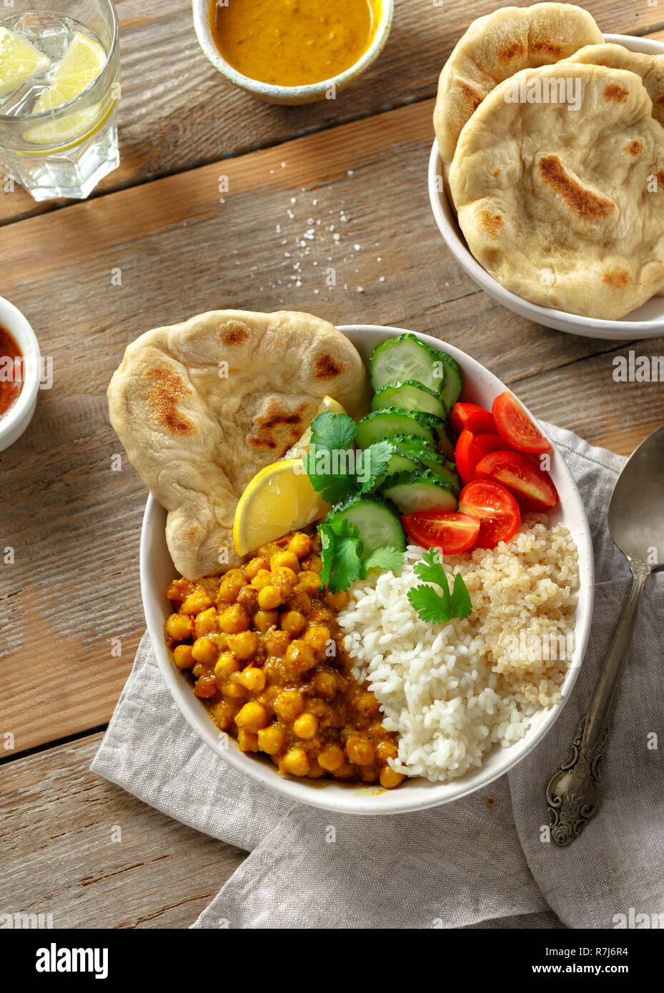 Vegan buddha Schüssel mit Naan Brot auf Holztisch, Ansicht von oben. Gesunde vegetarische Essen Konzept Stockfoto