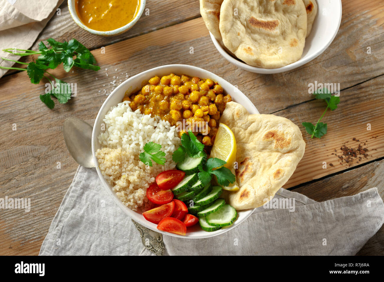 Vegan buddha Schüssel mit Naan Brot auf Holztisch, Ansicht von oben. Gesunde vegetarische Essen Konzept Stockfoto