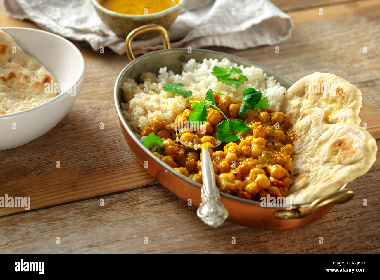 Kichererbsen in Curry, Reis und Quinoa in Wanne auf hölzernen Tisch. Leckere und gesunde Asiatische Mittagessen. Asiatische Lebensmittel Konzept Stockfoto