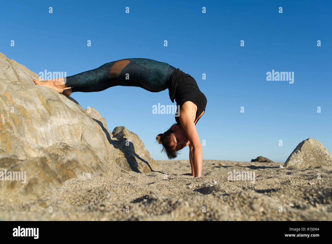 Argelès-sur-Mer (Frankreich). Dehnübungen nach dem Üben Yoga auf den Felsen vor der Racou Strand am frühen Morgen Stockfoto