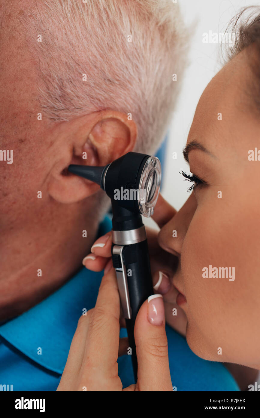 Der Arzt, der Prüfung älterer Mann Ohr mit otoskop Stockfoto