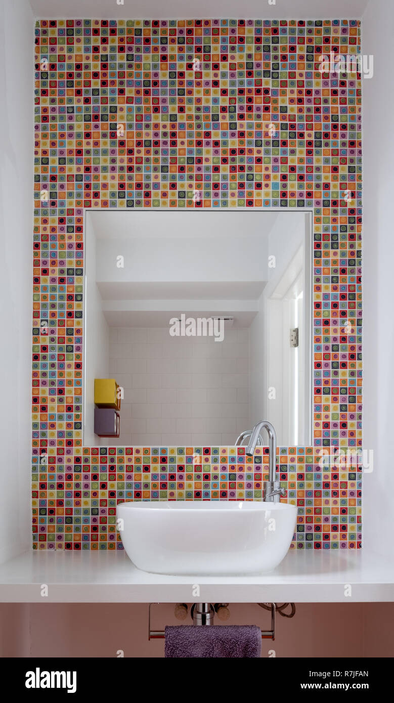 Modernes Badezimmer mit Waschbecken, bunten Glas Mosaik Fliesen, weiß  lackierten MDF Regal und Spiegel Einfügung in die Fliesen Stockfotografie -  Alamy