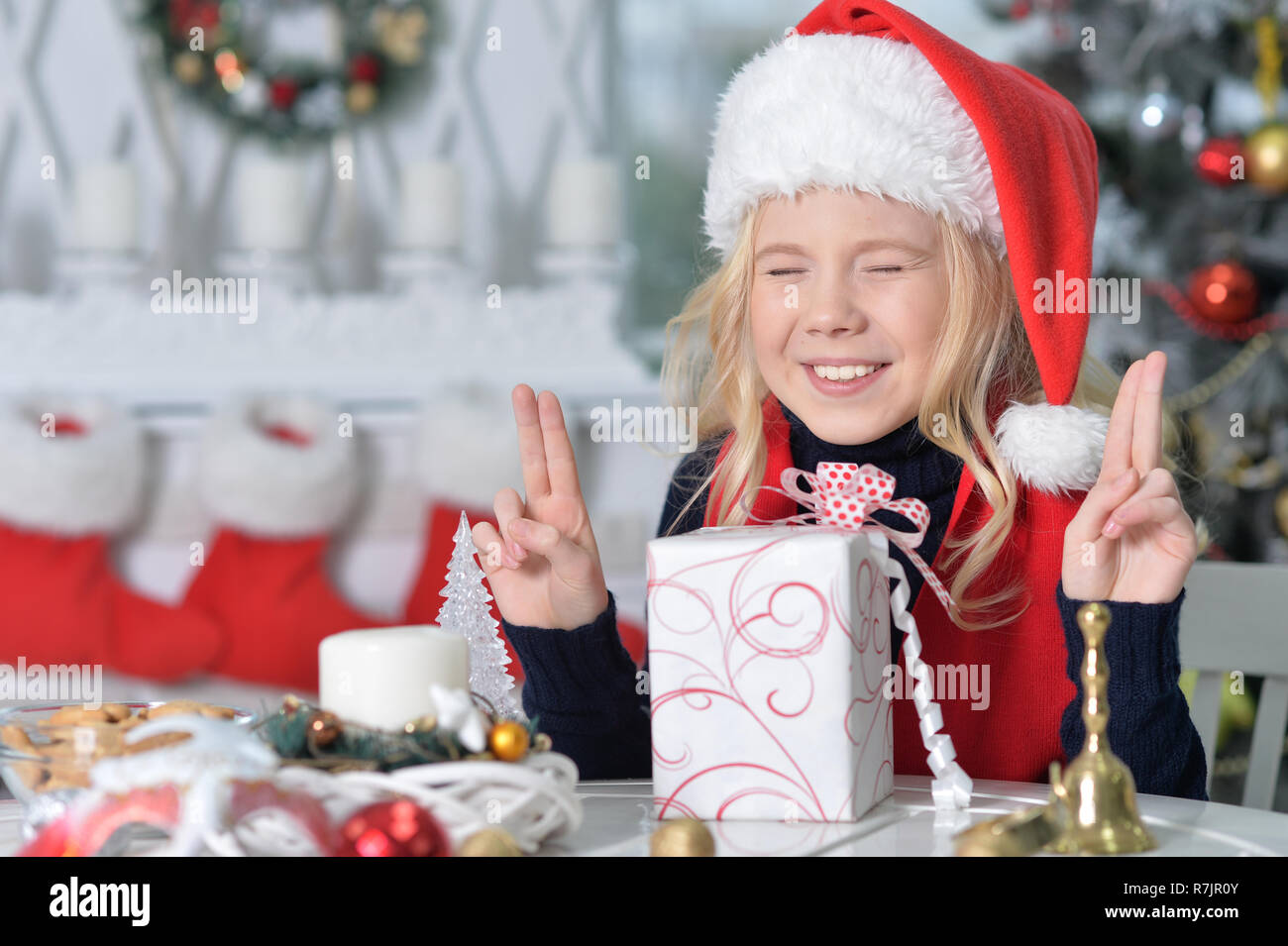 Portrait von glücklichen Mädchen in Santa Hut sitzen mit Weihnachten pres Stockfoto