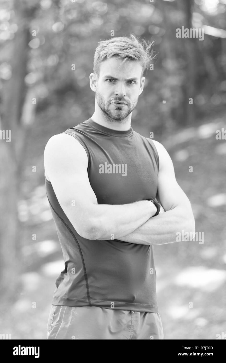 Sportler mit Waffen im Sommer Park durchquert. Starke Mann Bereit zum Training an der frischen Luft. Fit und zuversichtlich Macho. Sport und Training. In Wald oder Park entspannen. Wellness und Körperpflege. Stockfoto