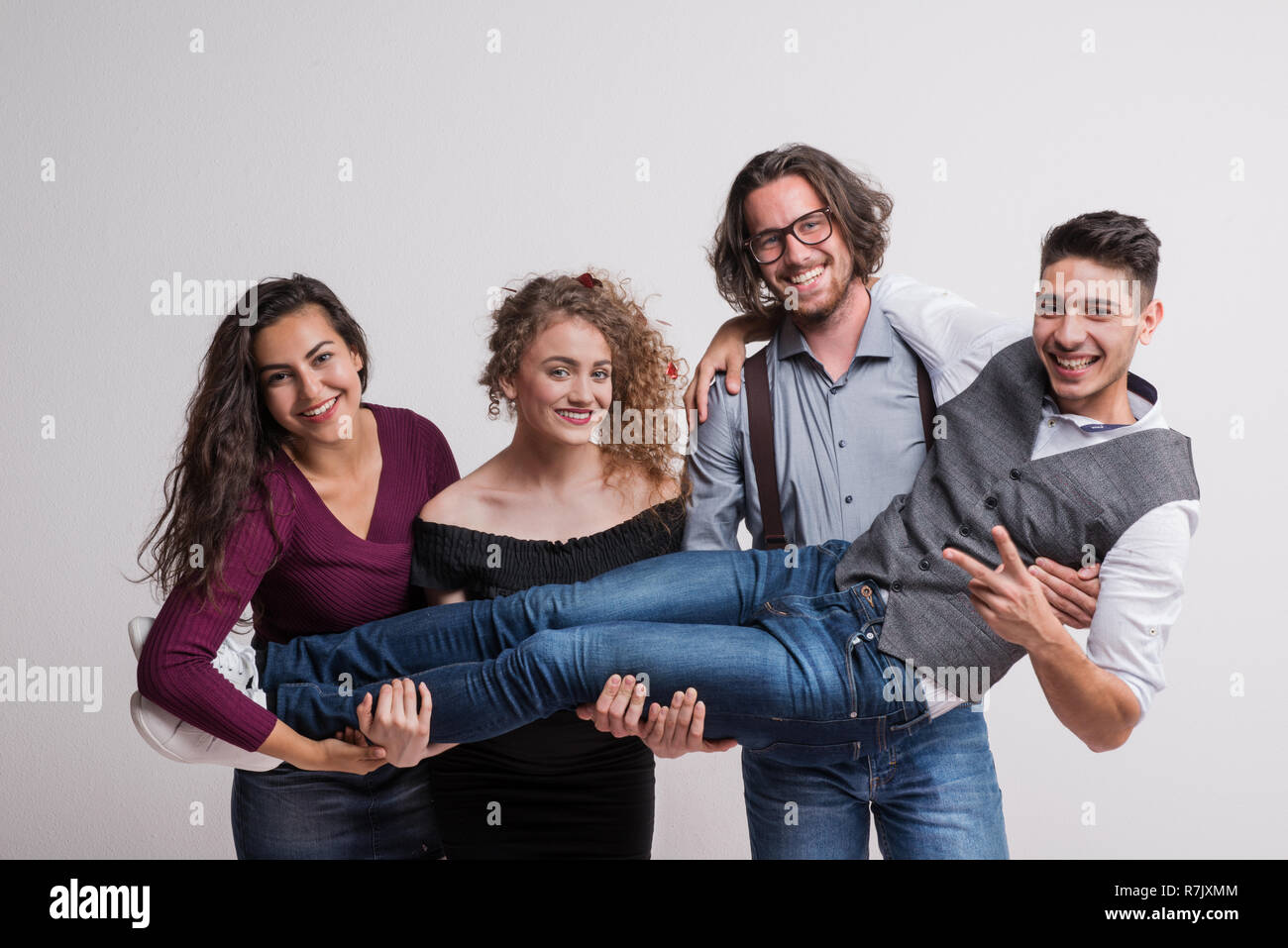Eine Gruppe von jungen Menschen mit einem Freund in einem Studio, genießen eine Partei. Stockfoto