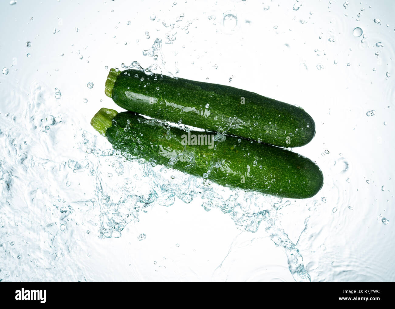 Zucchini Spritzwasser auf weißem Hintergrund Stockfoto