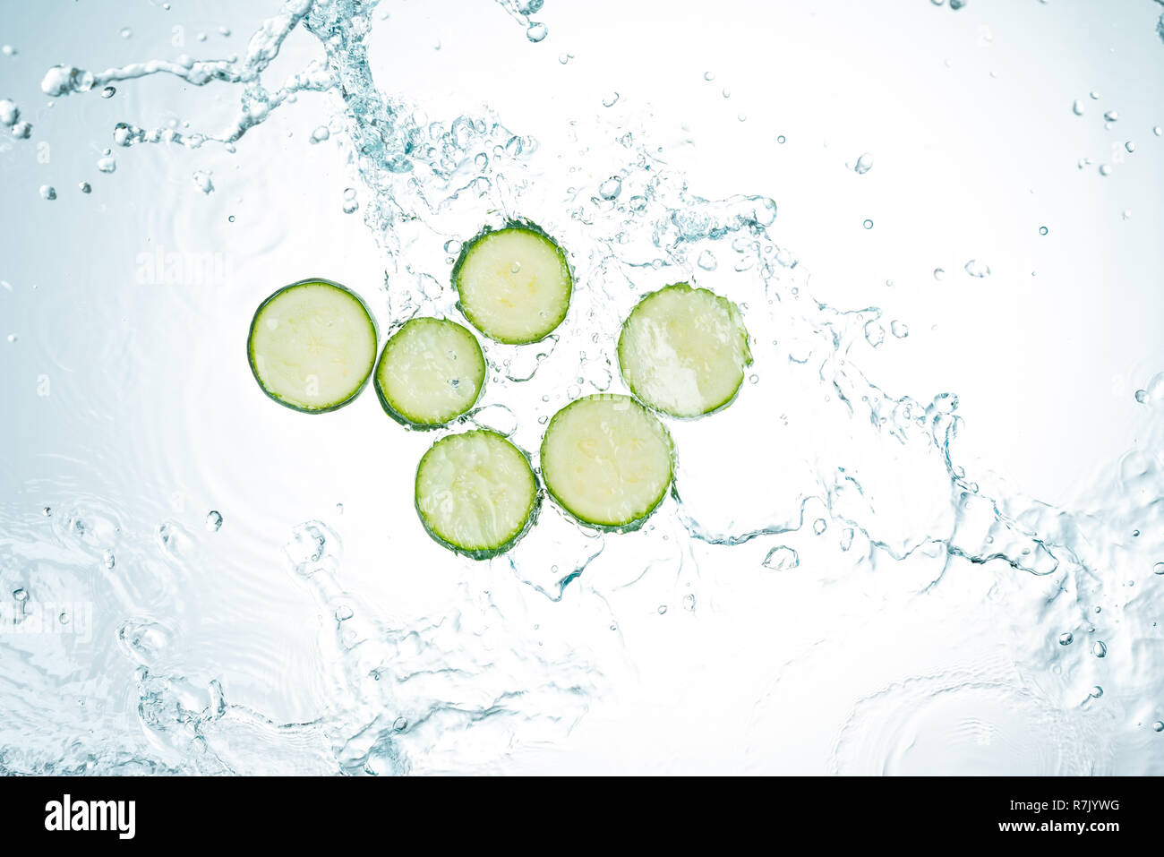 Zucchini Spritzwasser auf weißem Hintergrund Stockfoto