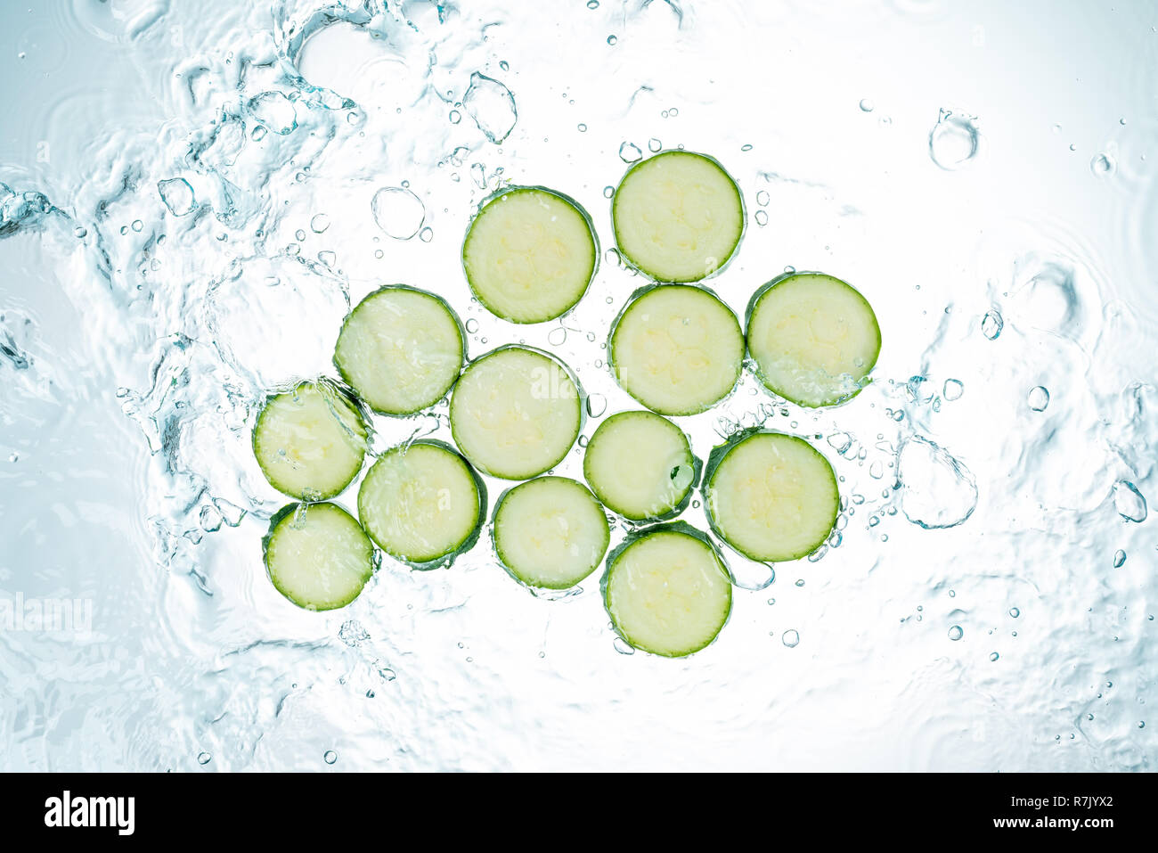 Zucchini Spritzwasser auf weißem Hintergrund Stockfoto