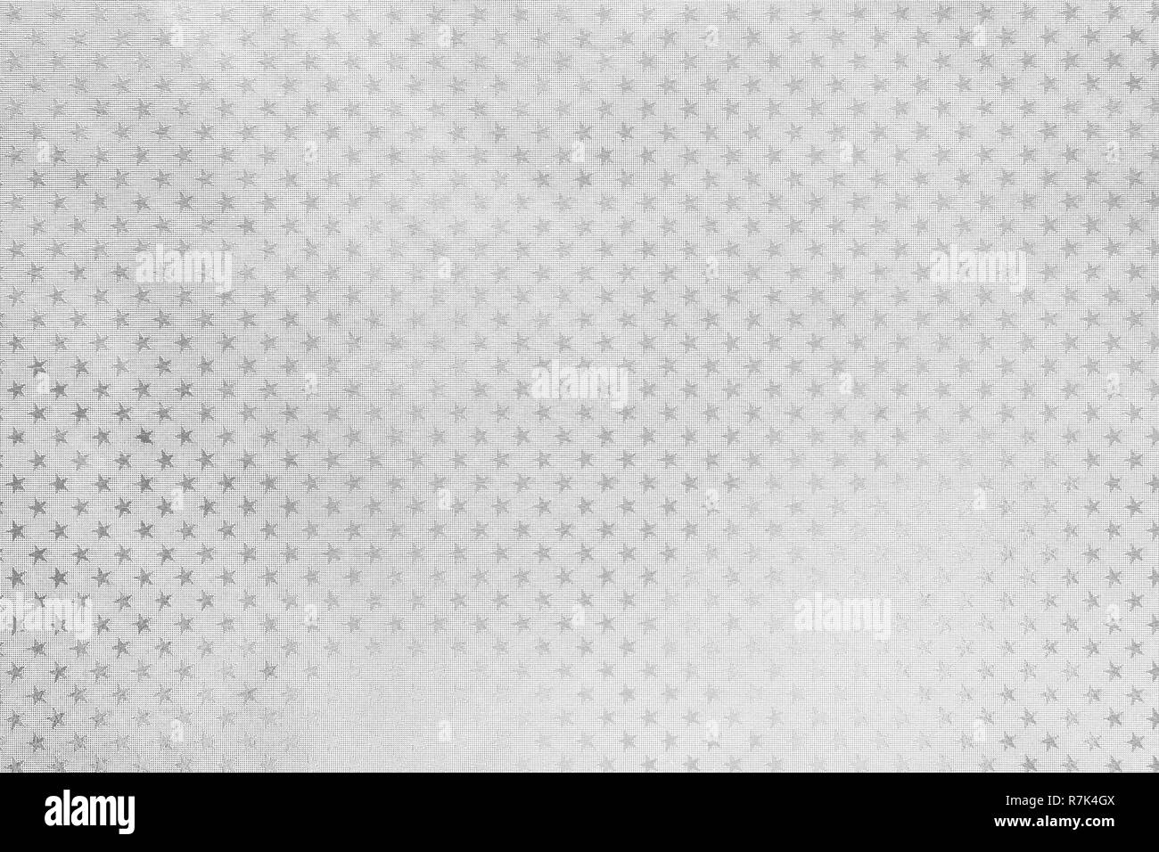 Weißer Hintergrund aus Metallfolie Papier mit einem Muster der funkelnden Sterne Nahaufnahme. Textur von Silber metallisierte Verpackung urlaub Papier Oberfläche. Stockfoto