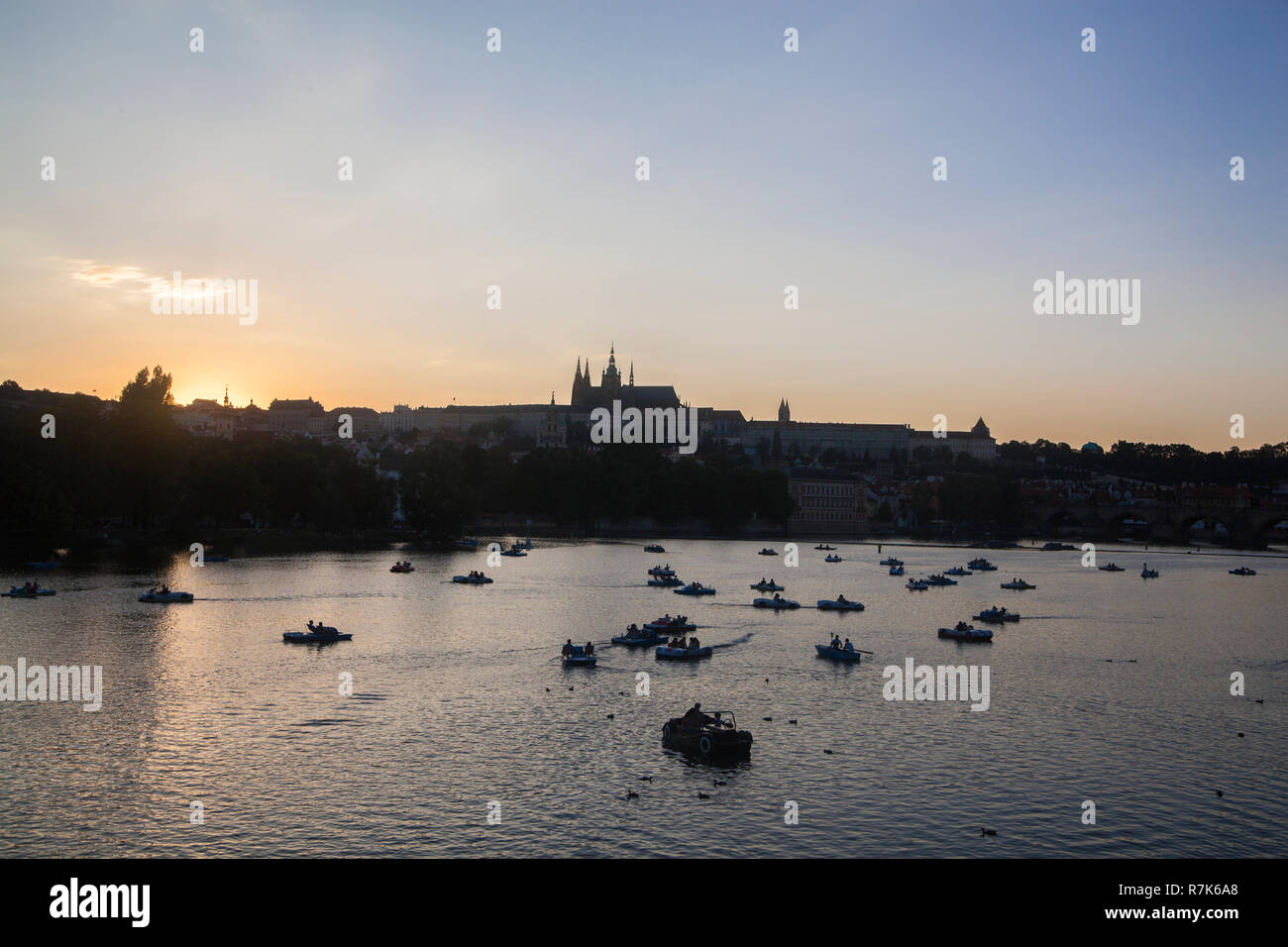 Die Prager Burg und die Boote auf dem Fluss Vltava bei Sonnenuntergang Stockfoto