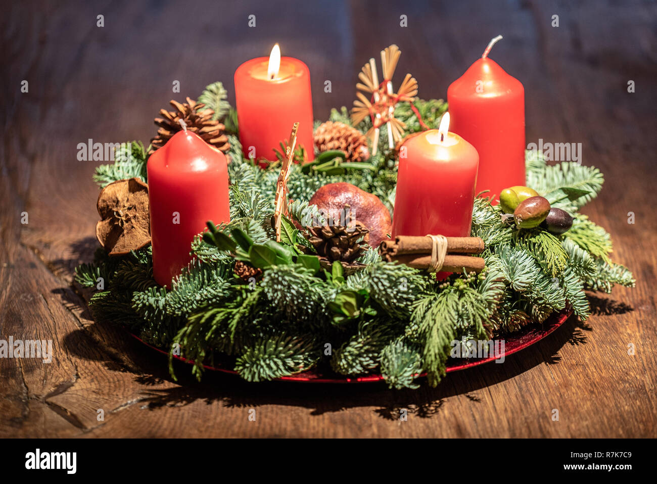 Adventskranz und zwei brennende rote Kerzen an einem hölzernen Tisch Studio  Stockfotografie - Alamy