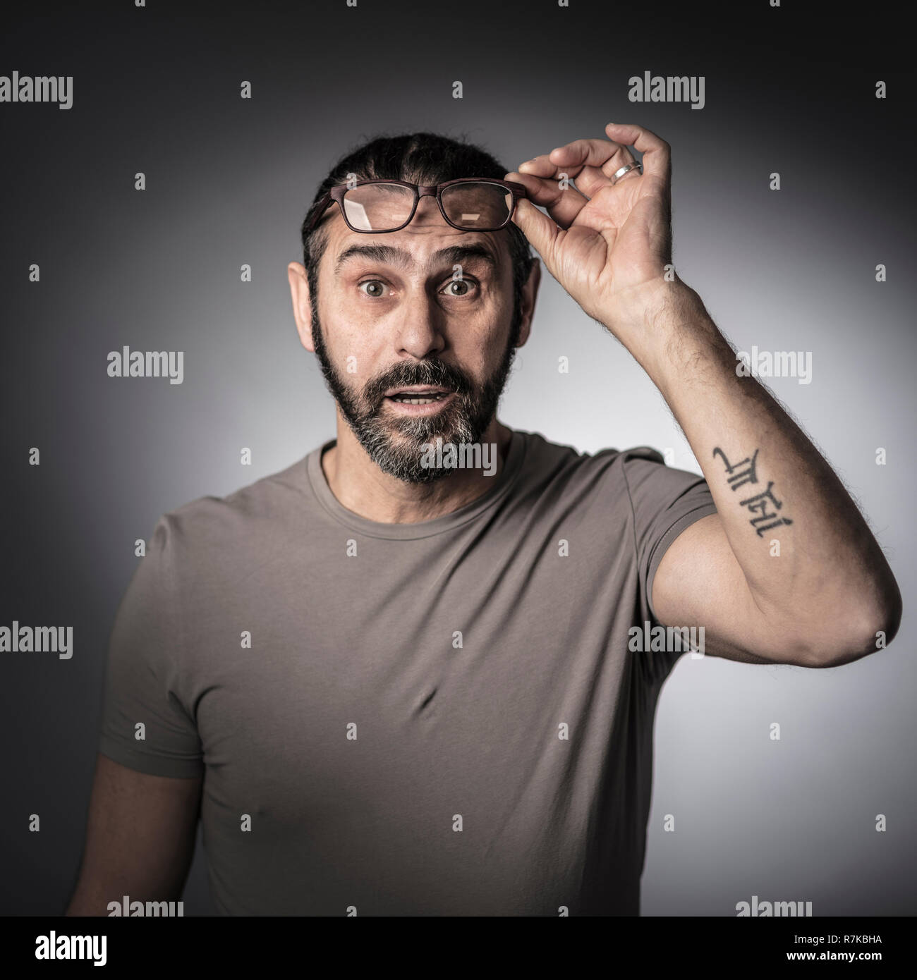 Portrait von überrascht Mann mit Brille studio Shot grauer Hintergrund Stockfoto