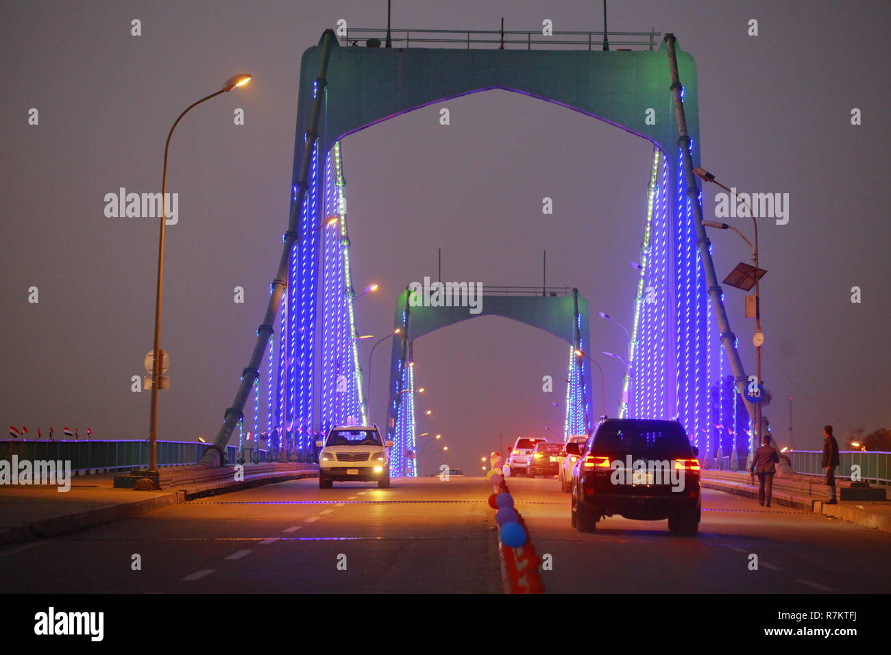 Bagdad, Irak. 10. Dezember, 2018. Autos fahren, den 14. Juli Brücke, die auf die irakische Hauptstadt Bagdad im südlichen Stadtteil Karrada in der so genannten Grünen Zone, wo die Regierungsbüros und westlichen Botschaften basieren, da der Bereich wurde teilweise wieder für fünf Stunden geöffnet, jeden Abend während einer Feier wiederholt werden, um die ersten Jahrestag der Irakischen Sieg über den islamischen Staat (IST) Gruppe auf einem Militärstützpunkt in den internationalen Flughafen in Bagdad zu markieren. Credit: Ameer Al Mohammedaw/dpa/Alamy leben Nachrichten Stockfoto