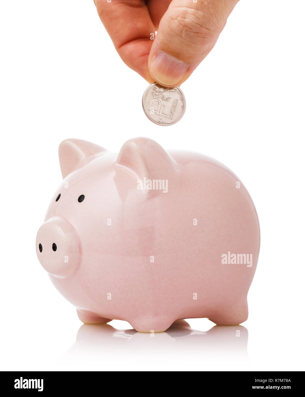 Die Hand eines Rubels in das Sparschwein. Konzept zum Thema der Einsparungen Stockfoto