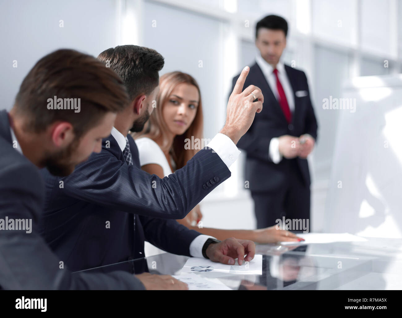 Mitarbeiter bei der Präsentation heben die Hand, um eine Frage zu stellen. Stockfoto