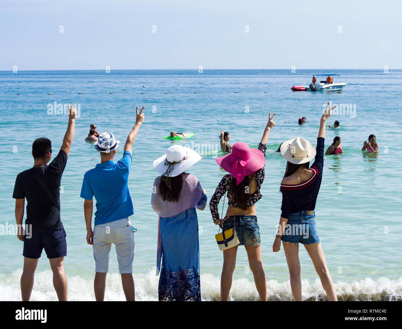 Silhouetten und Gruppe von fünf glücklichen asiatischen Menschen, die auf dem Hintergrund der leeren Sunset Beach. Reisen und meer ferien Konzept und Familie radeln Stockfoto