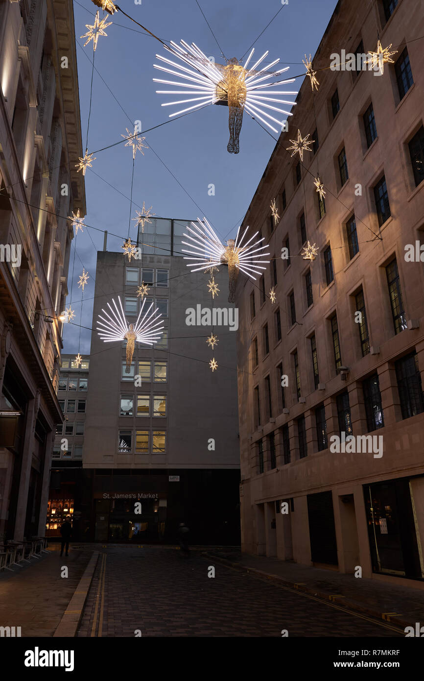 Engel Weihnachtsbeleuchtung aufhängen über Geschäfte im Carlton Street, St James Regent Street, London, 2018 Stockfoto