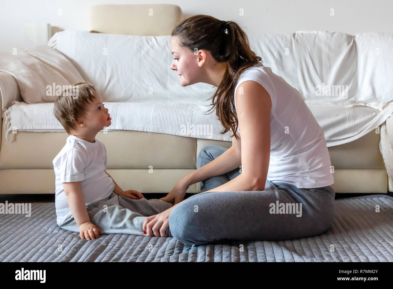 Niedlichen kleinen Jungen mit Down Syndrom spielen mit Mutter in Home Stockfoto