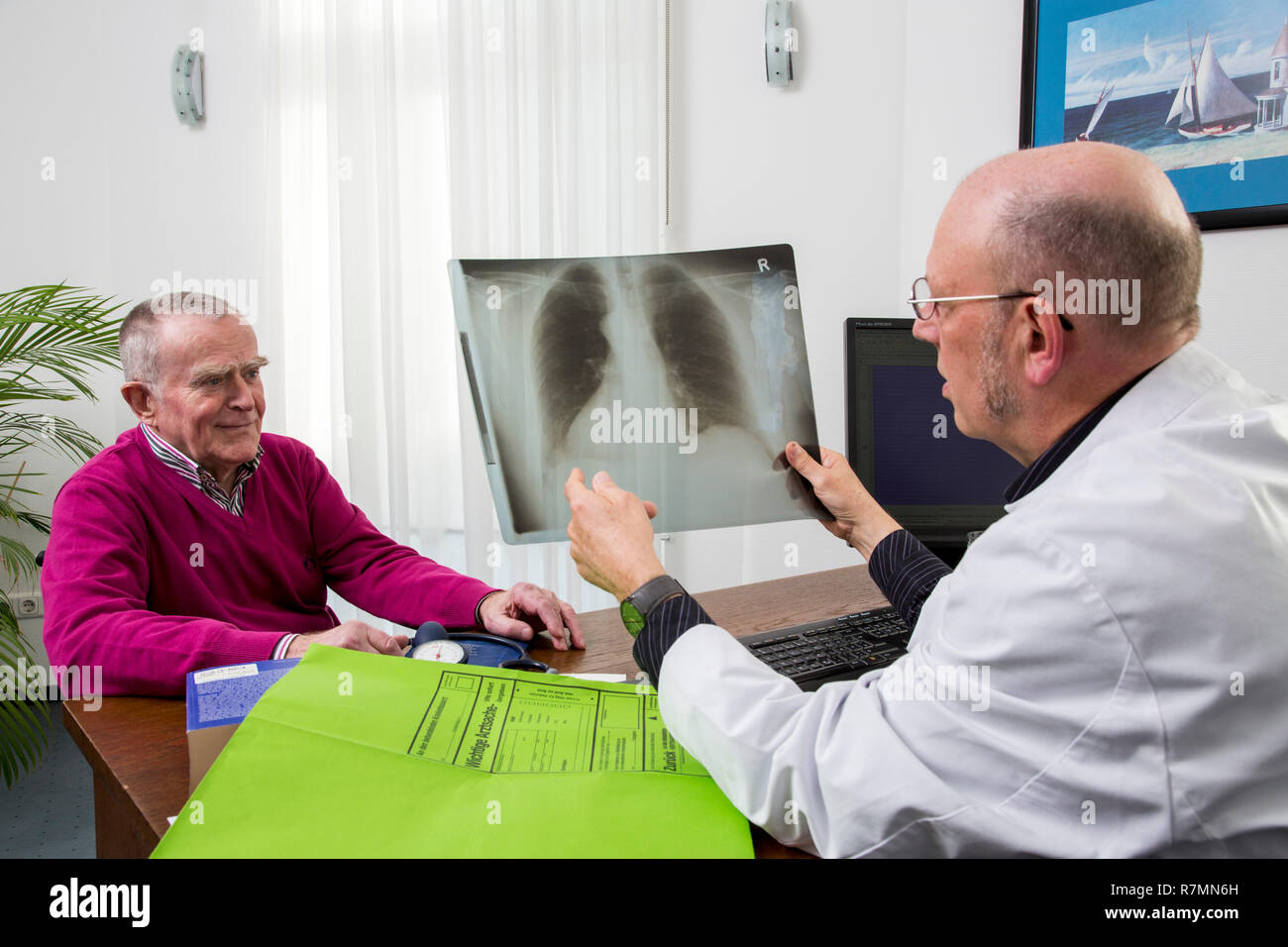 Eine Arztpraxis, Arzt ein Gespräch mit einem älteren Patienten über das Röntgenbild der Lunge, Deutschland Stockfoto