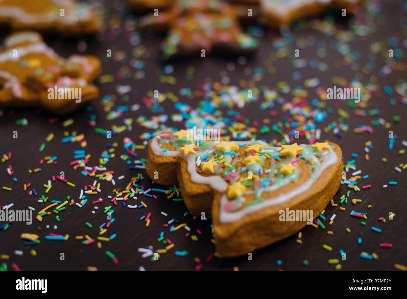 Weihnachtsbäckerei. Freunde verzieren frisch gebackene Lebkuchen Plätzchen mit Puderzucker und Süßwaren Dichtmasse, Ansicht von oben. Festliche Essen, Familie culi Stockfoto