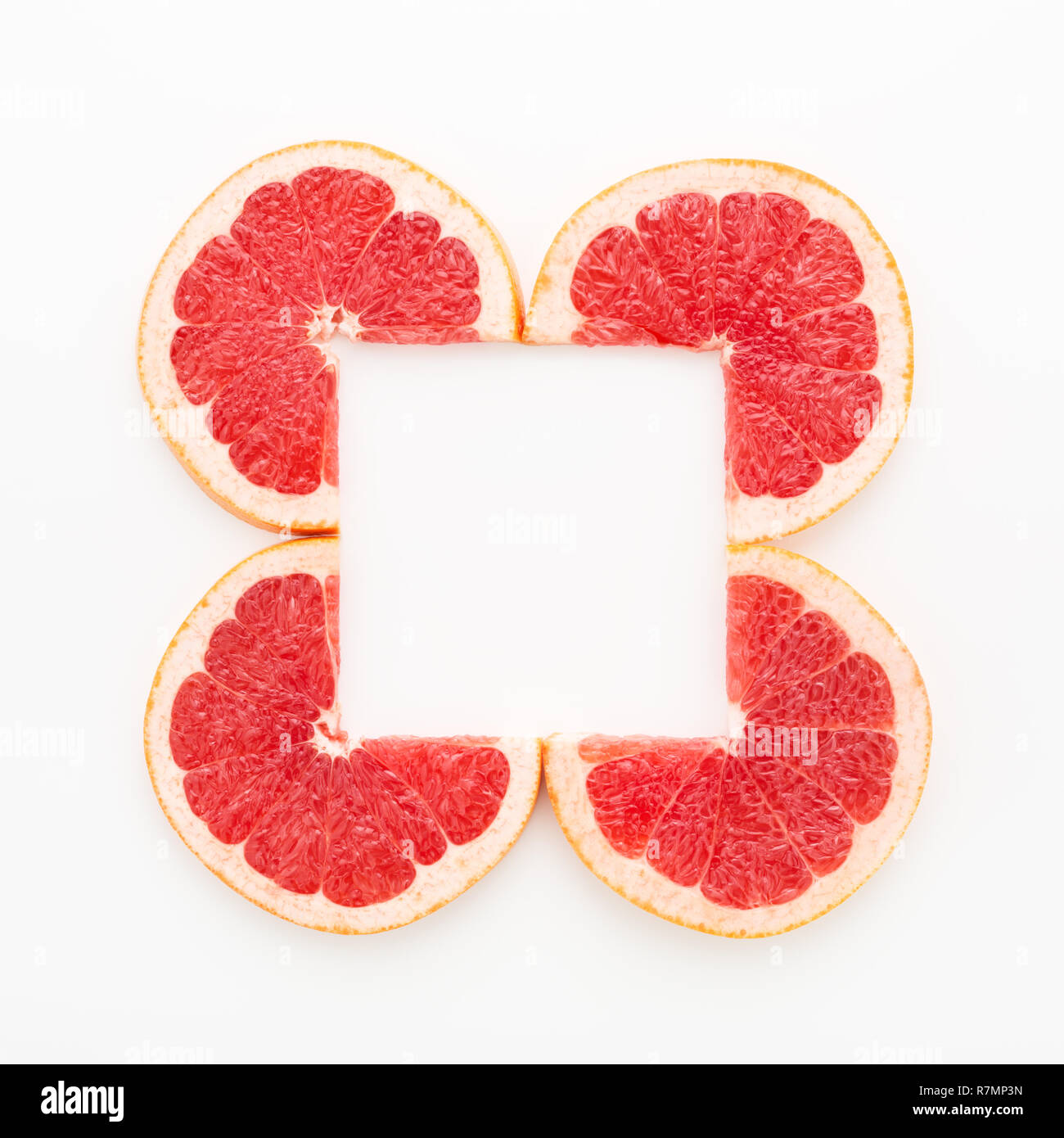 Kreative Rahmen der geschnitzten Grapefruit Schichten für lebende Koralle Farbe auf weißem Hintergrund. Minimal, Flach, kopieren. Stockfoto
