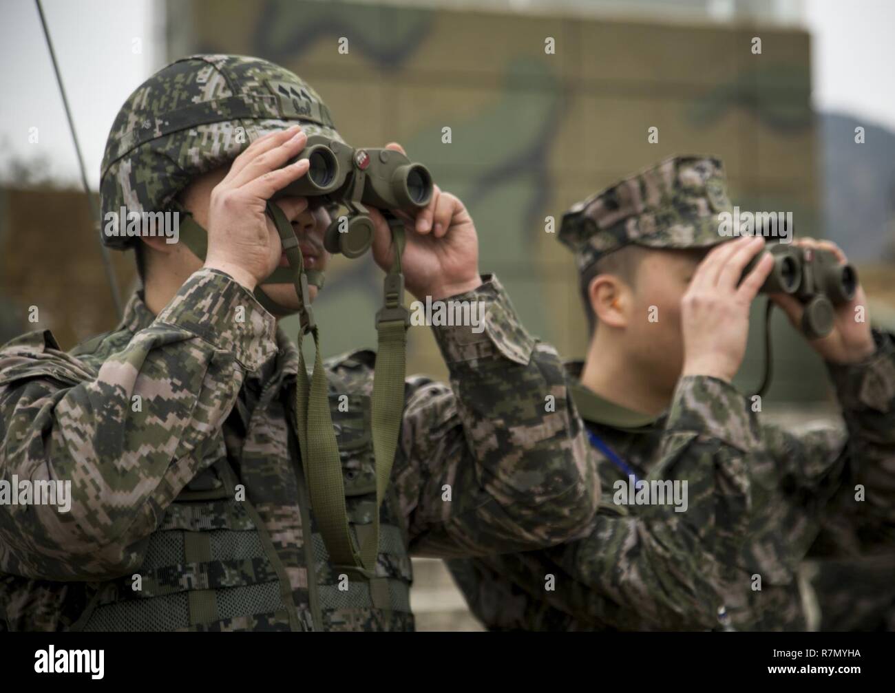 Republik Korea Marine Kapitän Jae Ente Lee mit 1 Amphibisches Fahrzeug Bataillon, 1st Marine Division und Staff Sgt. Nam Kyu Kim mit 1 Tank Bataillon, 1st Marine Division watch die Explosion von 1.750 Pfund C-4. März 20, 2017, at Susong Ri live Feuer Bereich, der Republik Korea, zur Unterstützung von Korea Marine übung Programm 17-6. Us Marine Corps Ingenieure mit Combat Assault Bataillon, 3rd Marine Division, III Marine Expeditionary Force in einer kombinierten Waffen Verletzung teilgenommen und schoss ein M58 Mine clearing Line (MICLIC) beim Training mit Ingenieuren und AAV Treiber von der ROK Stockfoto