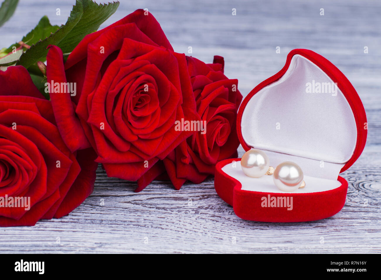 Ohrringe Schmuck Kästchen und rote Rosen. Rot blühenden Rosen und eine  Kiste mit Gold Schmuck auf Holz- Hintergrund. Valentinstag, Geburtstag oder  Hochzeit Stockfotografie - Alamy