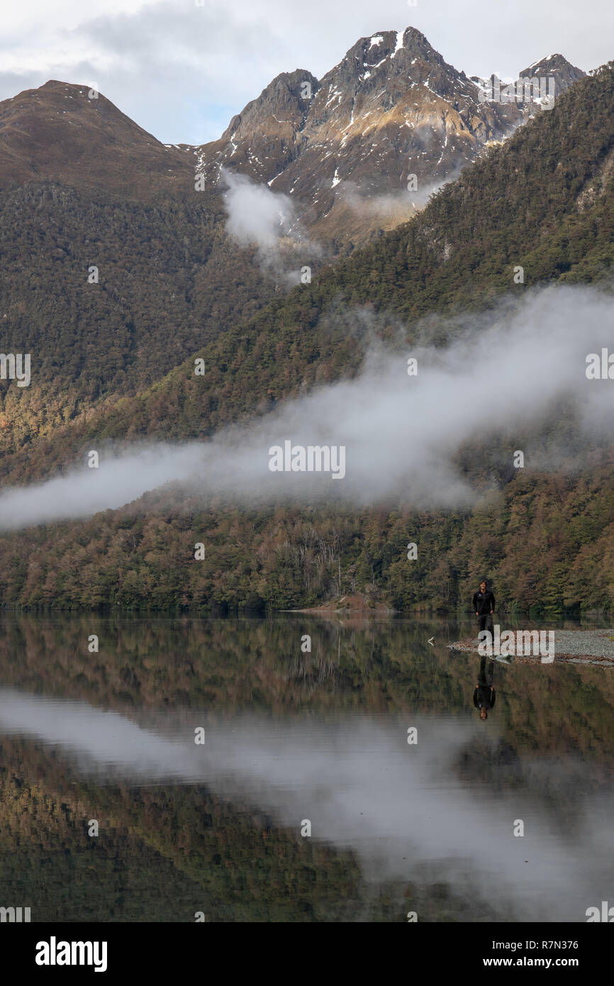 Eine Person am Lake Gunn mit Reflexionen, Neuseeland Stockfoto
