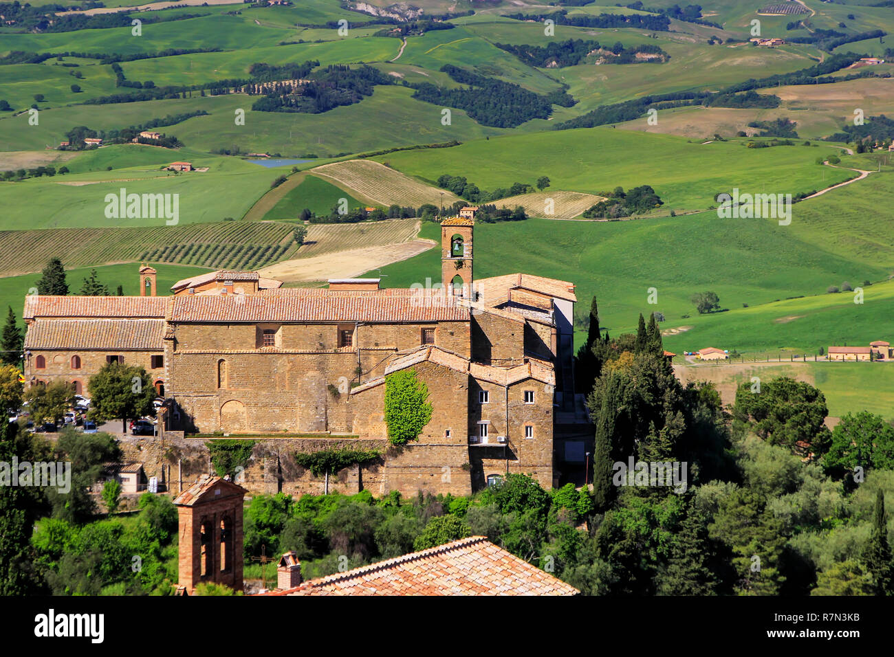 Alte Kirche und Feldern in Montalcino Stadt, Val d'Orcia, Toskana, Italien. Die Stadt hat ihren Namen von einer Vielzahl von Eiche, die einmal das t abgedeckt Stockfoto