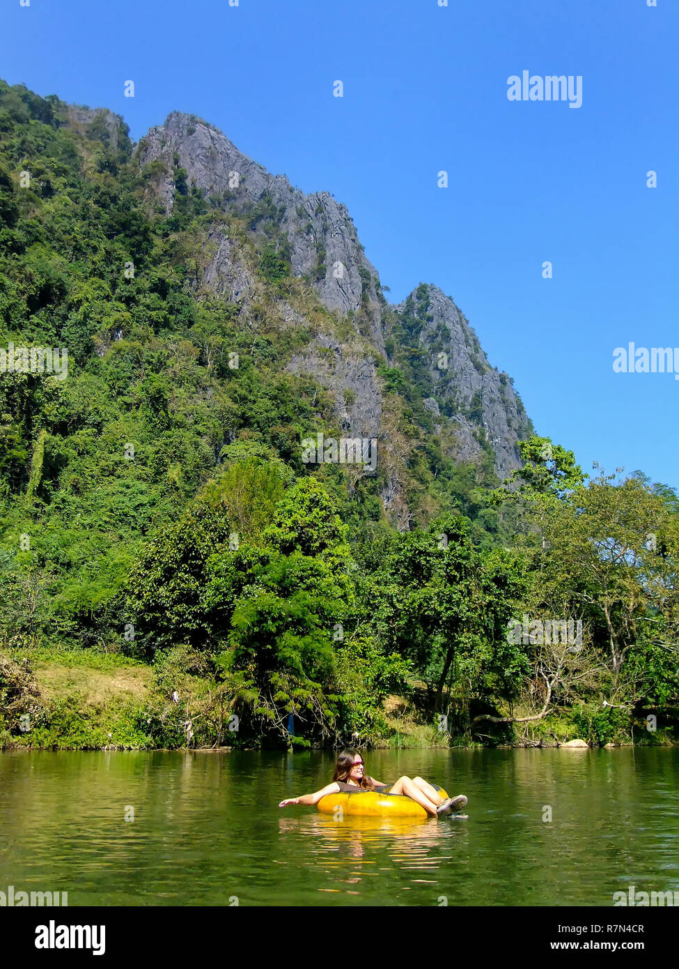 Touristische hinunter Nam Song Fluss in einem Rohr durch die Karstlandschaft in Vang Vieng, Laos umgeben. Tubing ist eine beliebte touristische Aktivität in Vang Vieng. Stockfoto